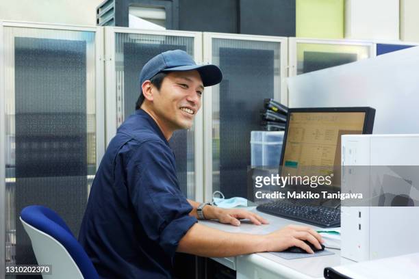 worker working on computer - coveralls ストックフォトと画像