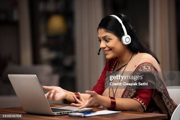 indian woman customer care representative sitting on chair at home:- stock photo - indian women stock pictures, royalty-free photos & images