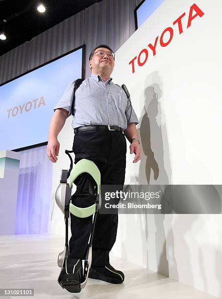 Eiichi Saito, a professor at Fujita Health University, demonstrates an "Independent Walk Assist" robot at a Toyota Motor Corp. News conference...