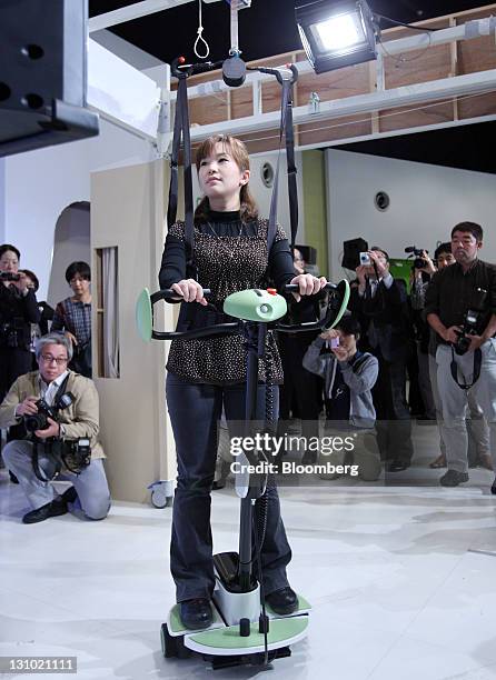 Model plays a video game as she demonstrates a "Balance Training Assist" robot at a Toyota Motor Corp. News conference showing new nursing and...
