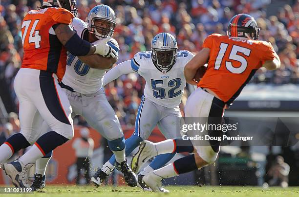 Linebacker Justin Durant of the Detroit Lions tries to contain quaterback Tim Tebow of the Denver Broncos as offensive lineman Orlando Franklin of...