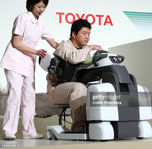 Models acting as a nurse, left, and patient demonstrate a "Patient Transfer Assist" robot at a Toyota Motor Corp. News conference showing new nursing...