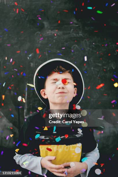 cute boy having fun with confetti in front of black background - cas awards stock pictures, royalty-free photos & images