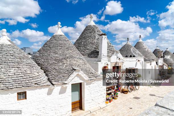 white trulli huts in summer, alberobello, puglia - unesco fotografías e imágenes de stock