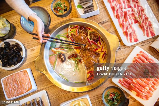 double flavor hot pot on the table. eating hot pot at restaurant. - feuertopf stock-fotos und bilder
