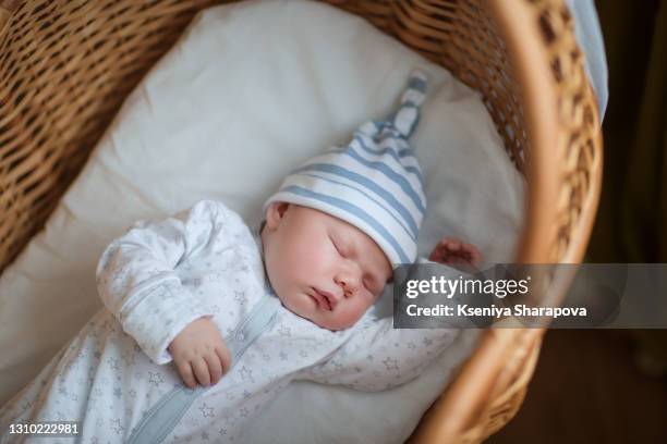 beautiful boy in white knitted fabrics and a hat, sleeping sweetly in bed-stock photo - man sleeping with cap stock pictures, royalty-free photos & images