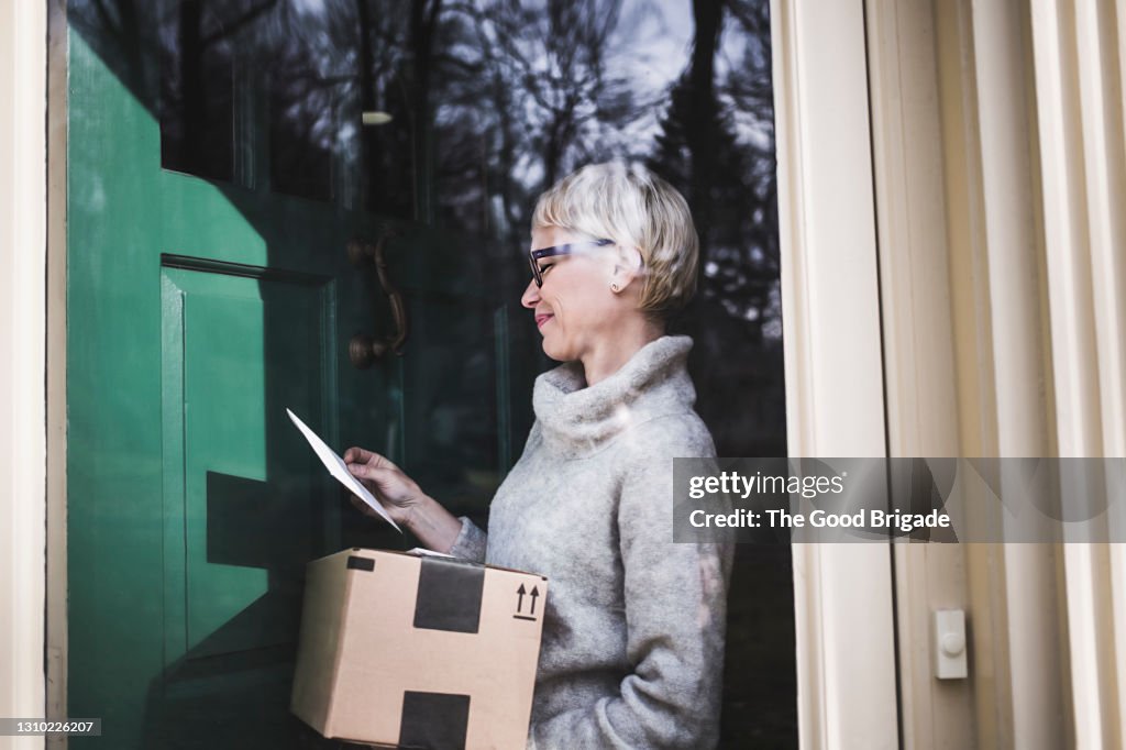 Woman receiving package at front door of home