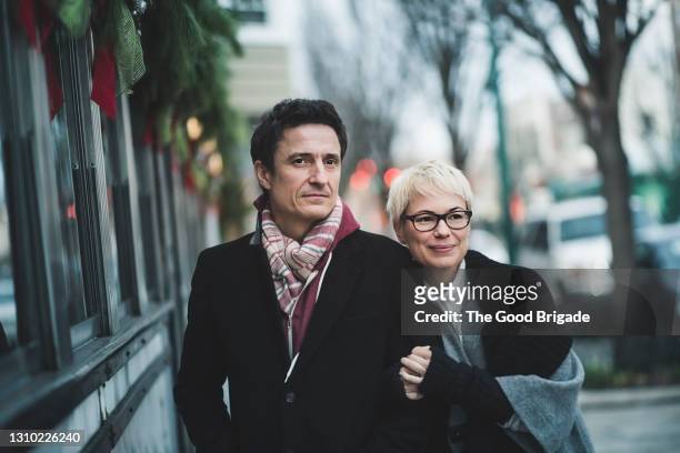 mature couple enjoying shopping in city - mature couple winter outdoors stock pictures, royalty-free photos & images