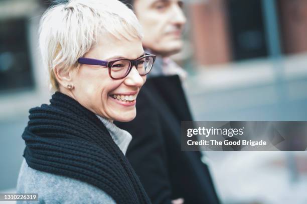 cheerful woman walking with husband in city - 2015 45 50 stock pictures, royalty-free photos & images