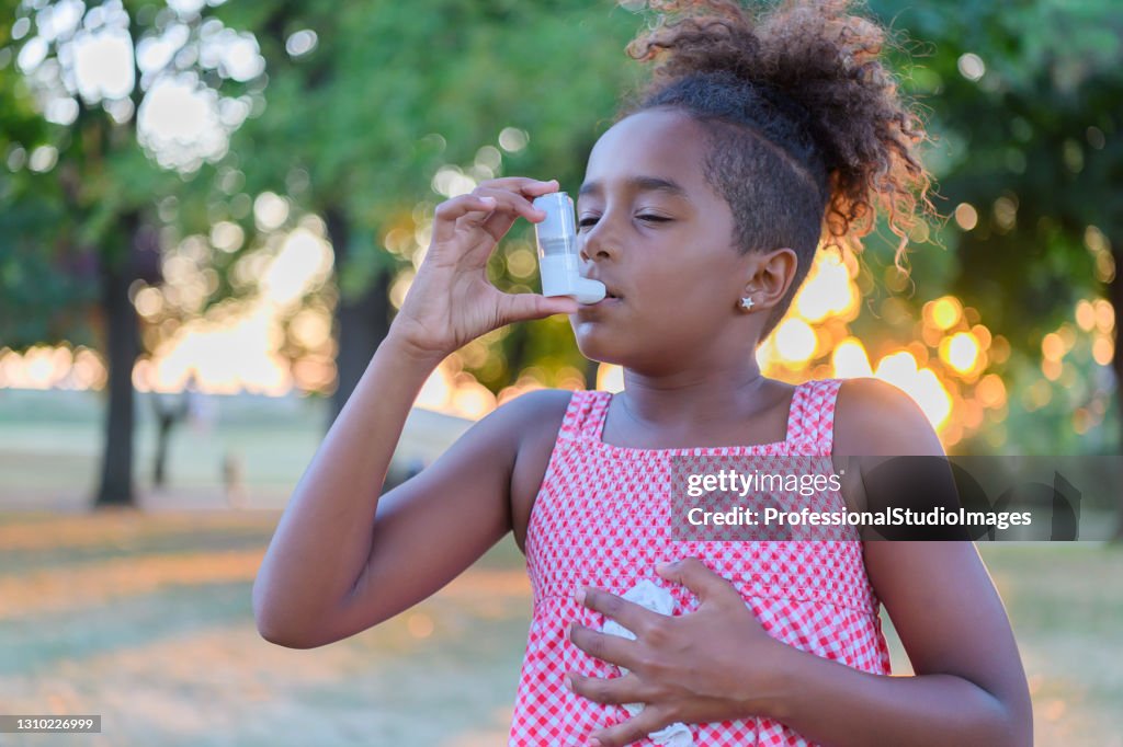 Beautiful Little African-American Girl is Having Asthmatic Problems Outside in Nature.
