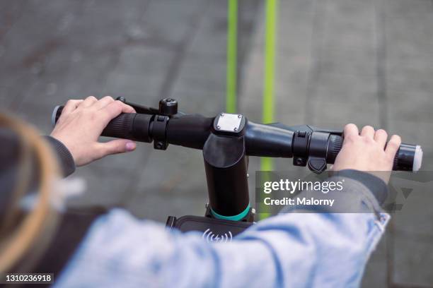 personal perspective of young woman riding an electric scooter in the city. - electric push scooter stock pictures, royalty-free photos & images