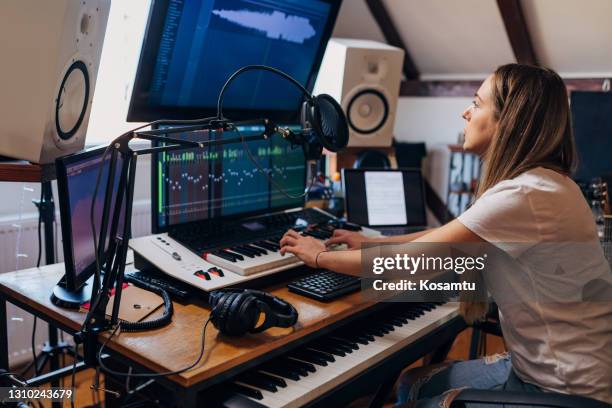 female music producer and sound engineer, using the electric keyboard musical instrument, to record some chords in her music studio - music producer stock pictures, royalty-free photos & images