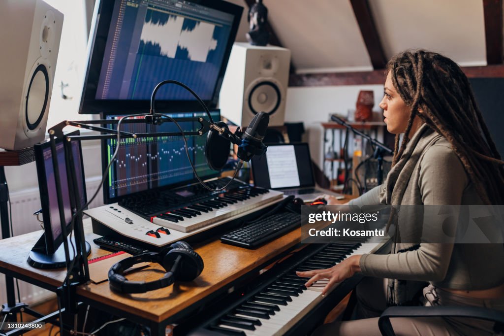 Engagierte junge Frau, eine Audio-Engeenerin, die an der Klangmischung aus ihrem Musik- und Tonstudio arbeitet