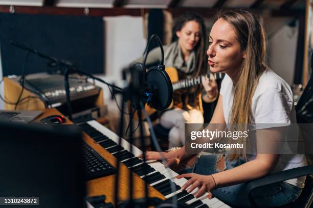 weibliche popmusik-band, eine probe im modernen musikstudio, gesang und spielen von musikinstrumenten - bandprobe stock-fotos und bilder