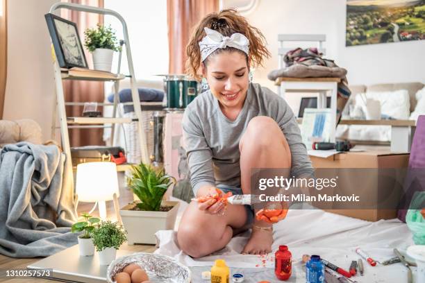 easter egg colouring. a young handsome woman artist paints easter eggs. a new style in decorating and painting easter eggs - an artistic impression - april 20 stock pictures, royalty-free photos & images