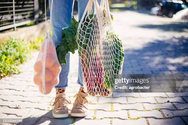 casual young woman hands holding bunch of different fruits and vegetables in recyclable string sack - ball of string stock pictures, royalty-free photos & images