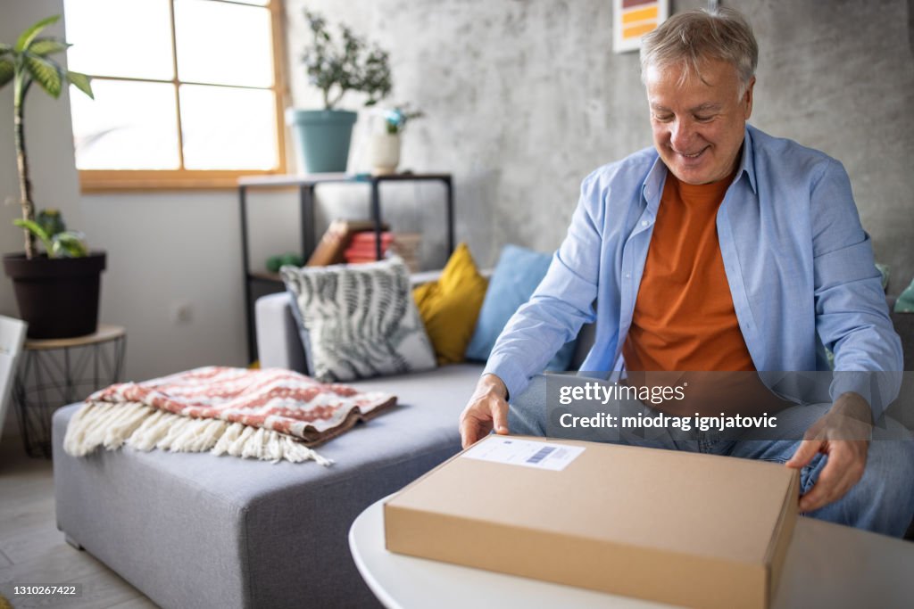 Box Sitting Senior Man Opening Delivery Cardboard Box After Online Shopping While ...