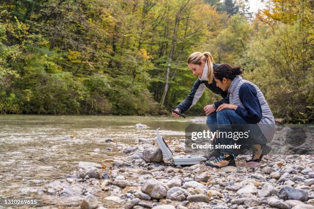 biologin untersucht wasserqualität mit digitalem gerät - forest scientist stock-fotos und bilder