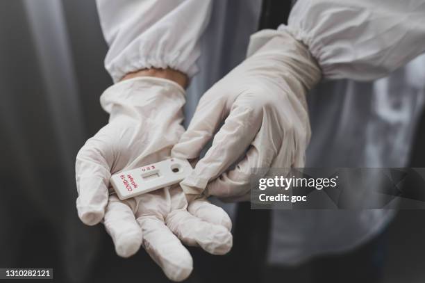 close-up of hand in surgical gloves holding the covid-19 rapid antibodies test kit - antibody testing imagens e fotografias de stock