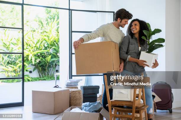 couple carrying cardboard box and pot plant in new house - carrying pot plant stock pictures, royalty-free photos & images