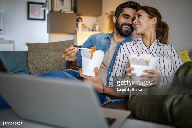 entrega a domicilio. pareja relajándose en casa y comiendo pasta - lovers 2020 film fotografías e imágenes de stock