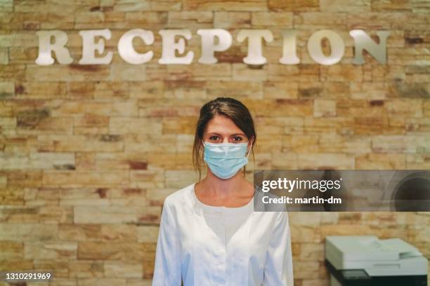 receptionist at work during covid-19 pandemic - hospital reopening stock pictures, royalty-free photos & images