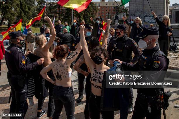 Policemen try to cover the body of FEMEN activists with body paint reading 'Legal fascism, national shame.' as they raise their fists during a...