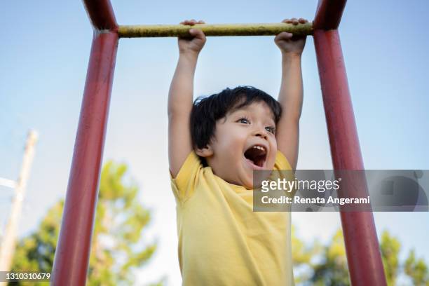 felice ragazzo giapponese asiatico che gioca nel parco giochi con t-shirt gialla - giochi per bambini foto e immagini stock