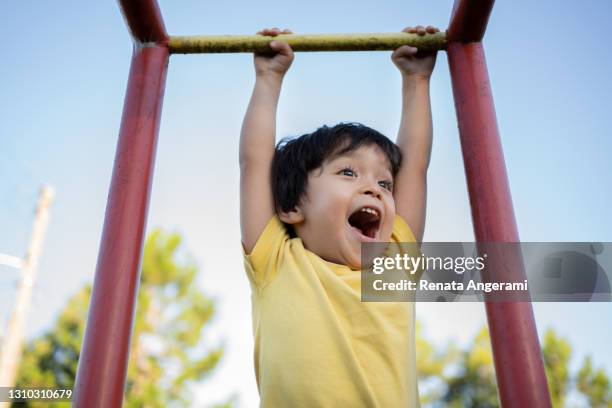 glad asiatisk japansk liten pojke leker på lekplatsen med gul t-shirt - children bildbanksfoton och bilder