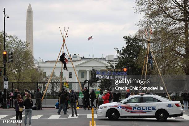 Indigenous environmental activists suspend themselves from large tripods, blocking traffic near Black Lives Matter Plaza on the north side of the...