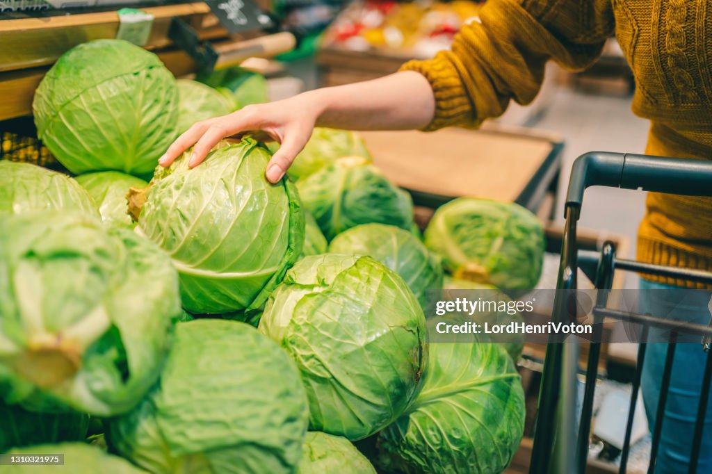 Frau kauft frischen Kohl im Supermarkt