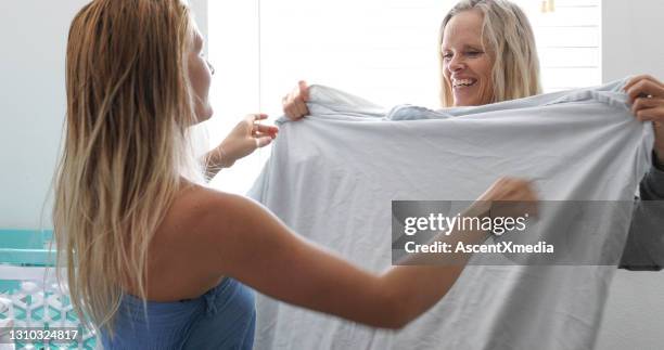 moeder en dochter vouwen wasgoed in de ochtend - bedsheets stockfoto's en -beelden