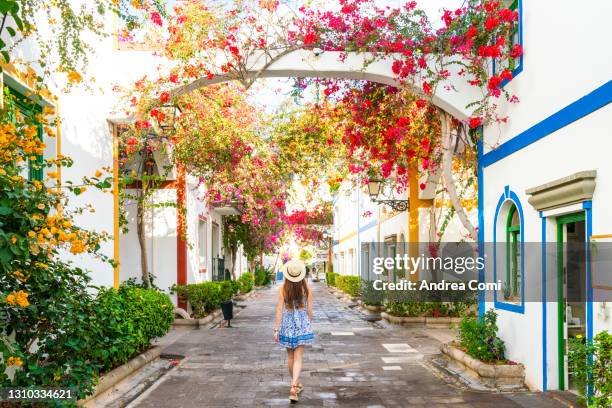 tourist walking along the flowery alleys of puerto de mogàn. canary islands, spain - canary islands bildbanksfoton och bilder