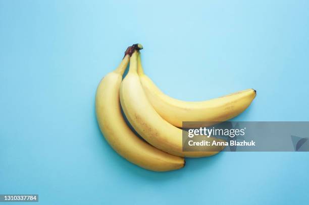 banana yellow fruits over blue background - green inspiring backgrounds imagens e fotografias de stock