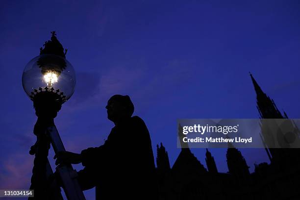 British Gas engineer Martin Caulfield services and cleans a gas lamp in Westminster on October 31, 2011 in London, England. Caulfield has been...