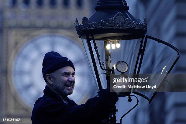 British Gas engineer Martin Caulfield services and cleans a gas lamp in front of Big Ben on October 31, 2011 in London, England. Caulfield has been...