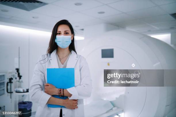 portrait of a female doctor in the ct scanner room - cancer research mask stock pictures, royalty-free photos & images