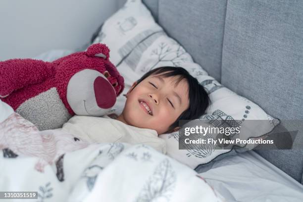 happy boy going to bed - boy asleep in bed stock pictures, royalty-free photos & images