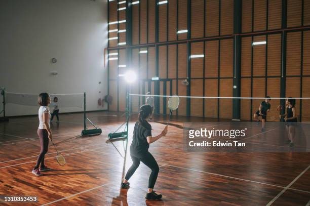 asiatische chinesische badmintonspielerinnen spielen im badminton - badminton court stock-fotos und bilder