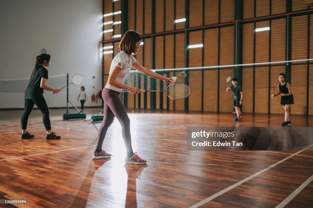 Asian chinese female badminton players playing in badminton cour