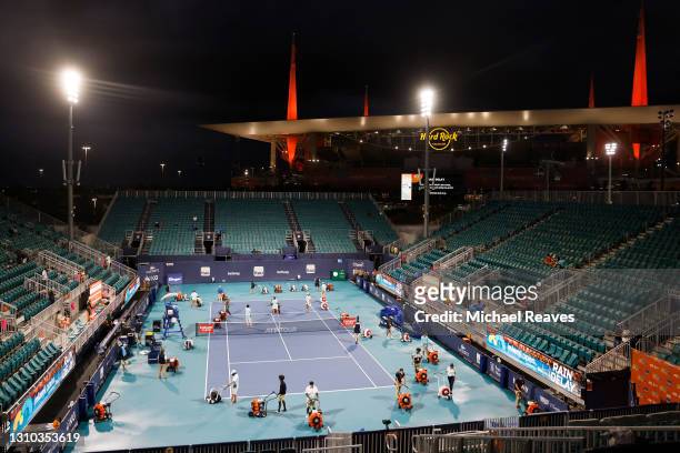 Miami Open staff work to dry the court after rain delayed the quarterfinal match between Andrey Rublev of Russia and Sebastian Korda of the United...