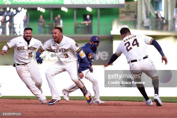 Orlando Arcia of the Milwaukee Brewers celebrates with teammates after driving in the game winning run during the tenth inning against the Minnesota...