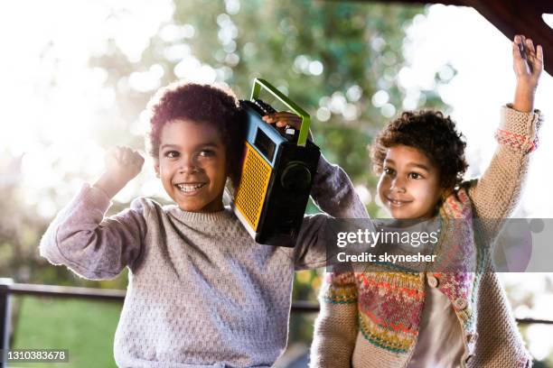 cool black kids having fun with a radio on a balcony. - listening to radio stock pictures, royalty-free photos & images