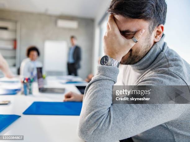 male entrepreneur feeling depressed on a meeting in the office. - disappoint bussiness meeting stock pictures, royalty-free photos & images