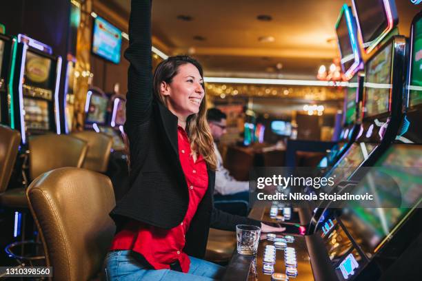 woman winning on slot machine in casino - jackpot stock pictures, royalty-free photos & images