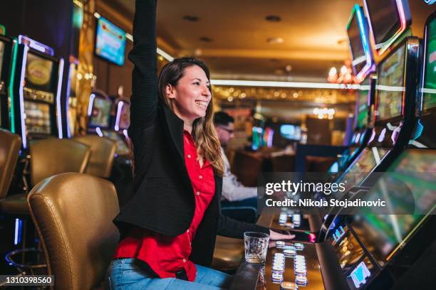 woman winning on slot machine in casino - jackpot stock pictures, royalty-free photos & images