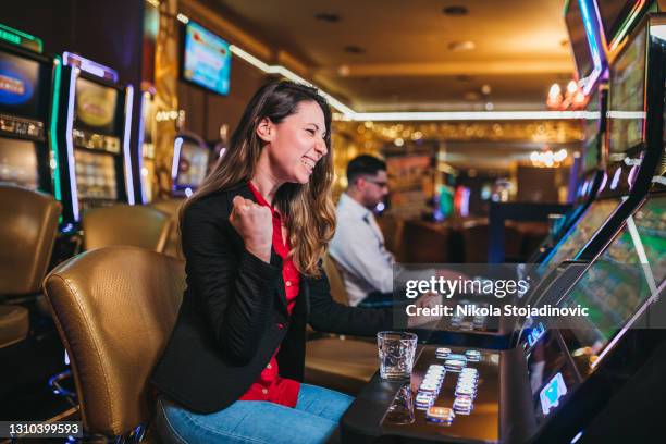 vrouw die op slotmachine in casino wint - casino worker stockfoto's en -beelden