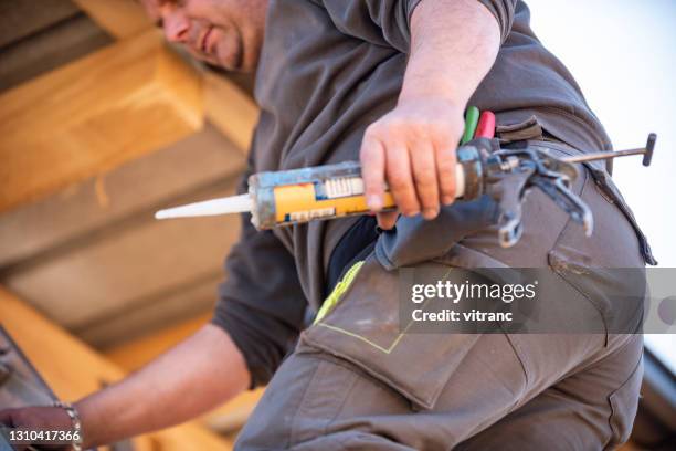 worker installing new gutter, caulking - gutter sealant stock pictures, royalty-free photos & images