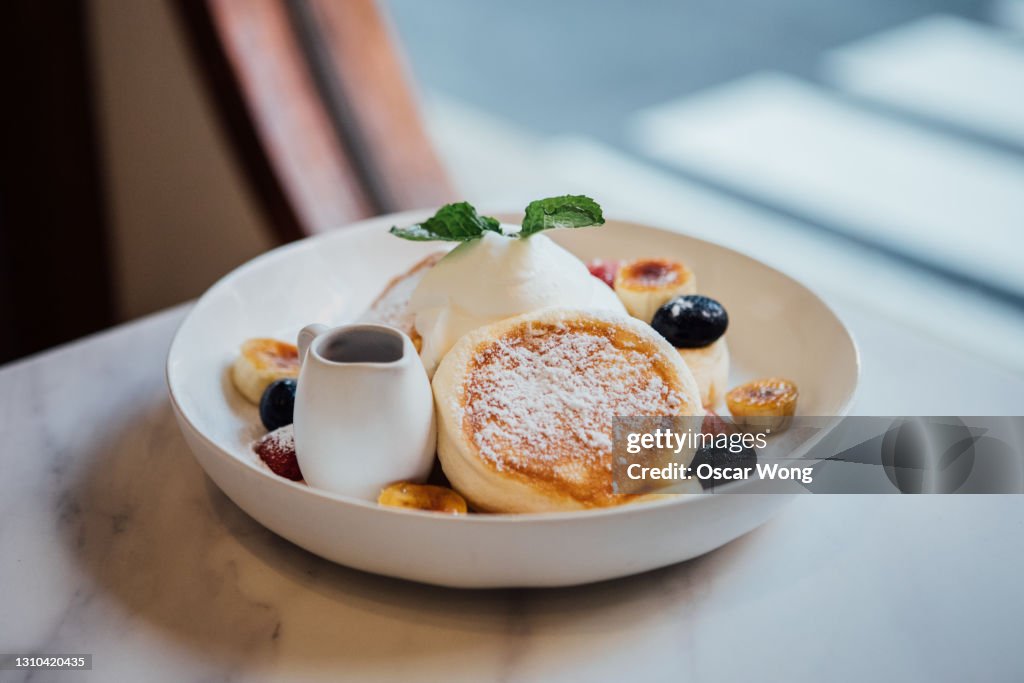Pancake With Whipped Cream And Fruits Freshly Served On A Marble Table
