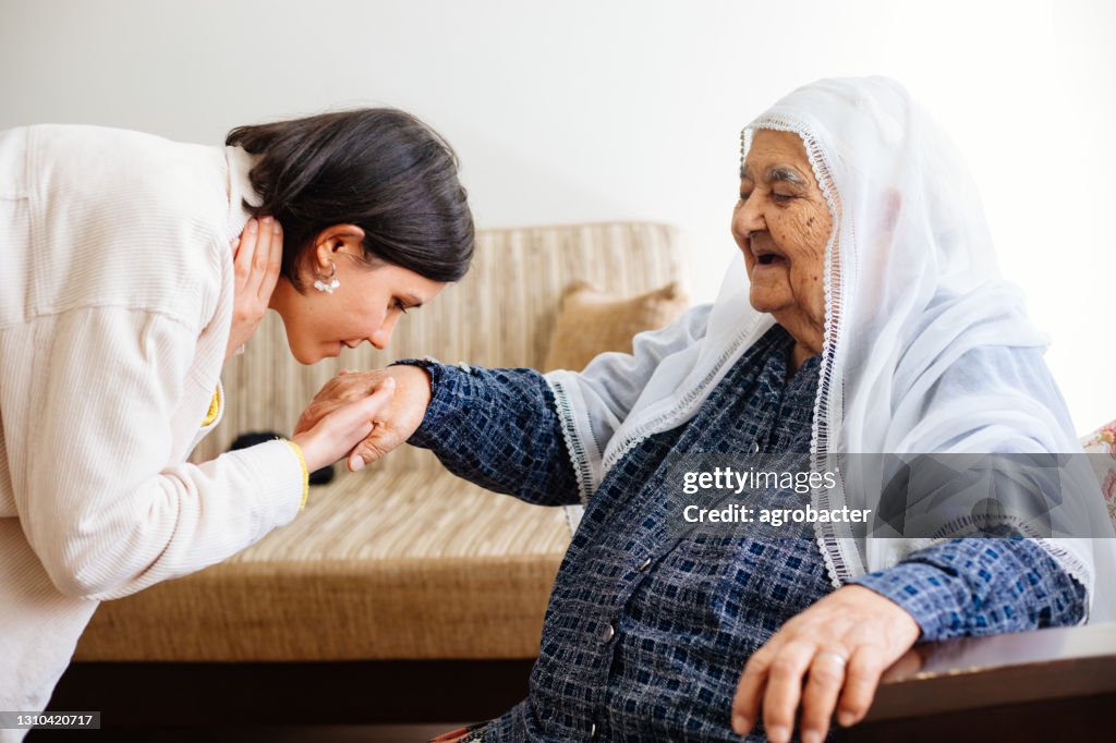 Granddaugther kissing grandmother's hand